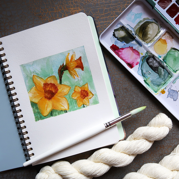 Woollen Wytch February sub club box - yarn subscription box theme reveal - watercolour painted daffodils on a pale blue green background