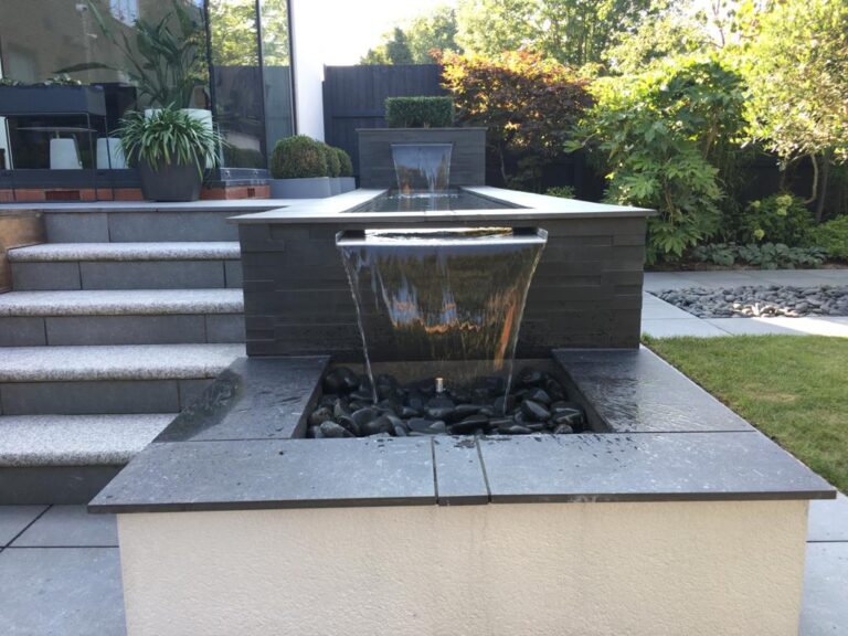 water feature with waterfall alongside steps in a garden