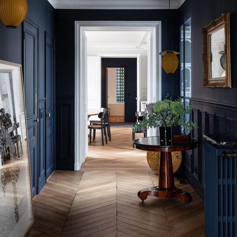 Long hallway leading to other rooms painted in dark blue.