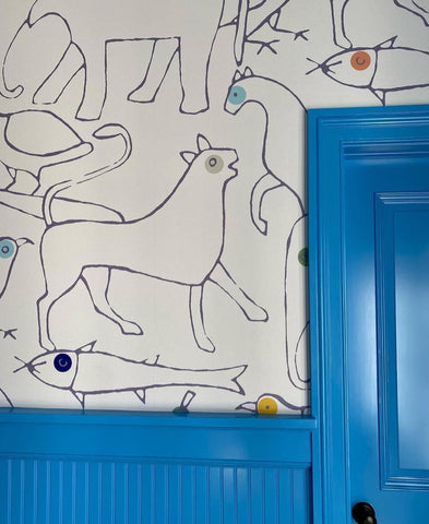 Wallpaper with black fine line animals and blue door.