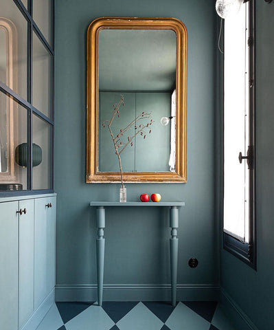 Turquoise hallway with small table and mirror.