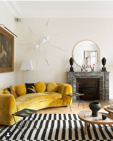 Living room with yellow couch and stripped carpet