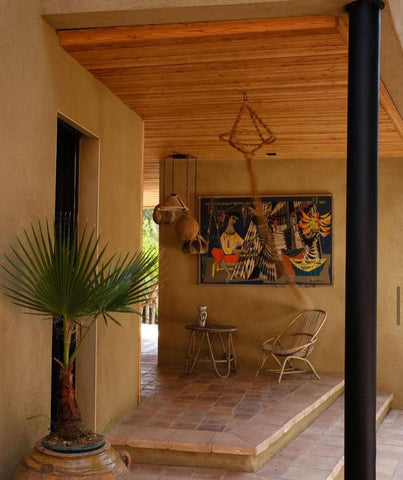 Exterior entry way decorated with a plant and a painting 