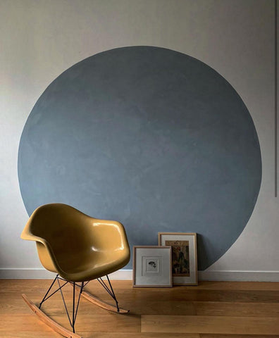 Wall with a circle painted on it, rocking chair in front of it