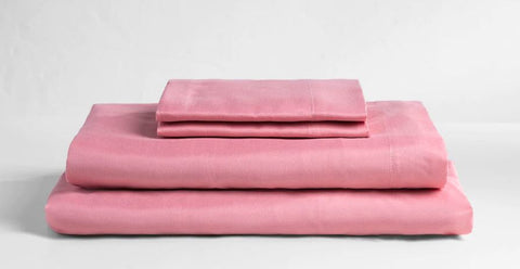 Stack of luxury bedding: Pink microfiber sheets showcasing elegance and comfort for your bedroom