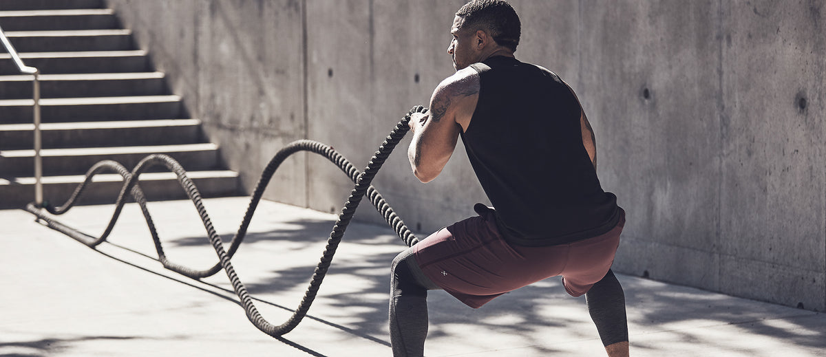 Man working out outside using battling ropes