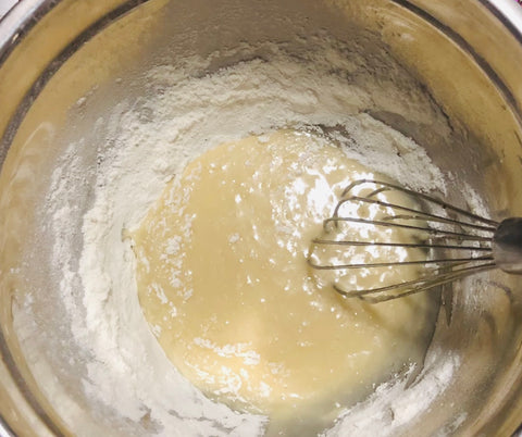 whisking flower and liquid in bowl