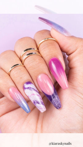 purple acrylic nails with multiple patterns