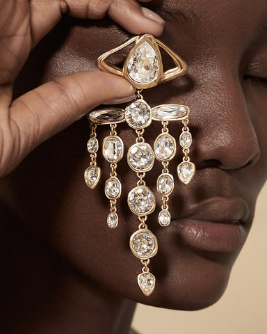 Rhinestone chandelier earrings that evoke Cocteau’s eye brooch for Schiaparelli.