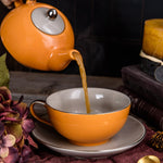 Théière orange qui verse du thé