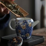 Feuilles de thé qui se versent dans une théière bleue et blanche
