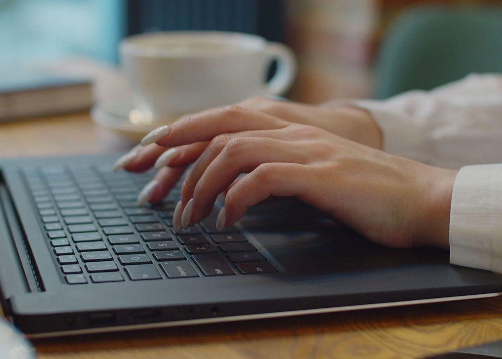 Women with long fingernail typing on laptop