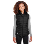 Woman standing with a black custom puffer vest from Spyder for women on and gray sweater