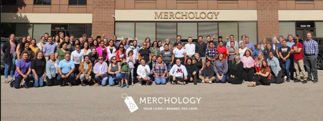 A large group of well-dressed professionals standing outside of the Merchology headquarters in Minneapolis, MN