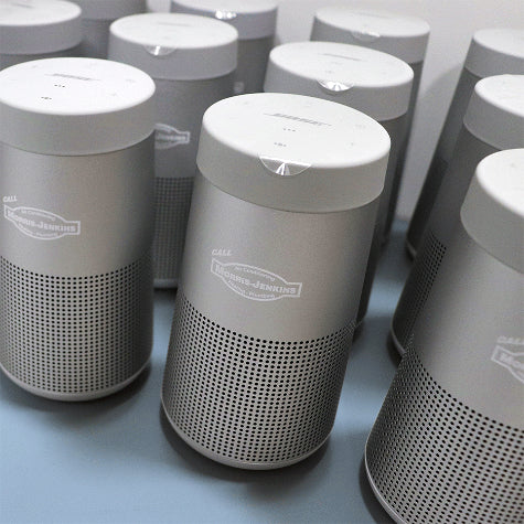 Corporate Bose speakers with a custom company logo printed on the front from Merchology