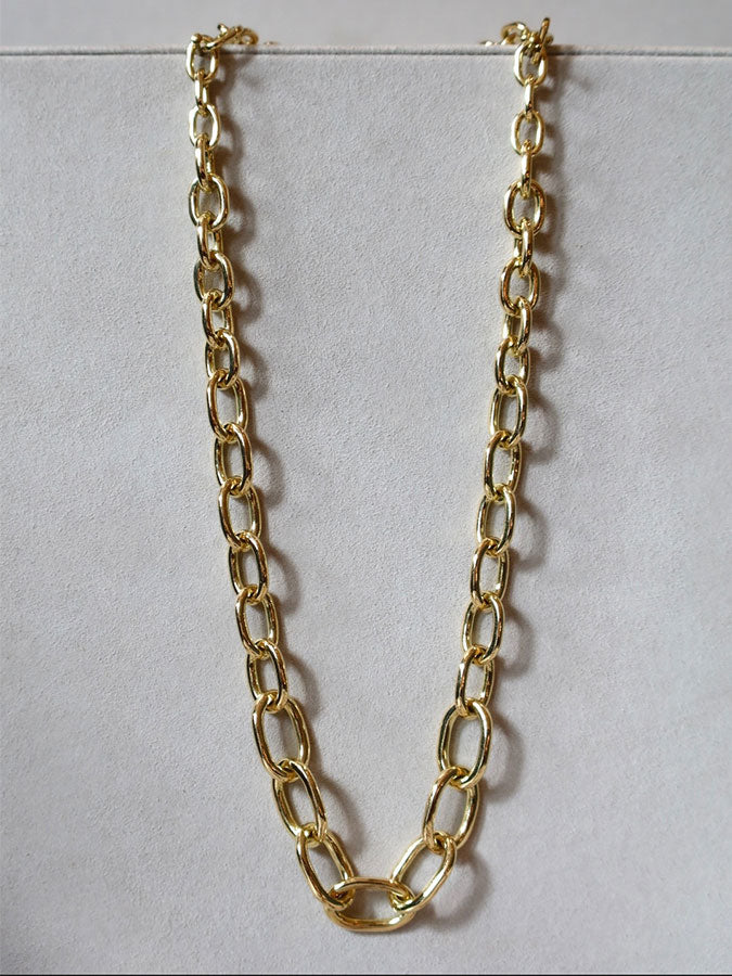 Luna gold necklace on grey background