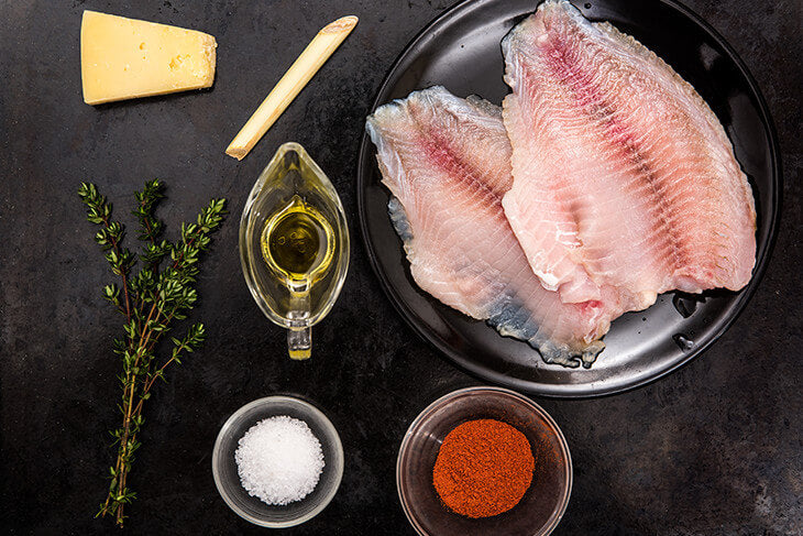 Fish fillet on a cutting Board with a knife, spices, oil and