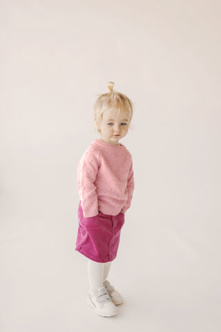 Toddler wearing Jamie Kay Wanderlust Dotty Knit in Marshmallow and Corduroy Mini skirt in blossom with Ribbed Tights in Milk