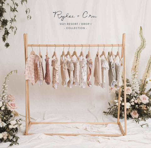 Rylee + Cru Resort Collection Spring Summer 2021 Drop 1 preview photo - clothing rack of swim and apparel coming in this collection, in a room with floral accents 