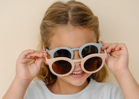 Grech & Co New 2021 Summer sunglasses lifestyle shot - little girl wearing the blue and pink matte round sunnies made of recycled plastic