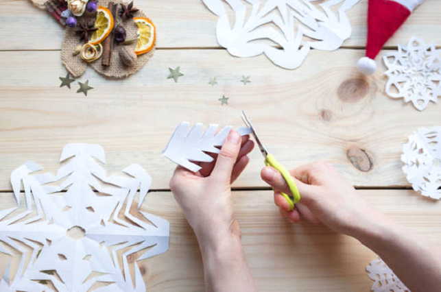 cutting out christmas paper snowflakes