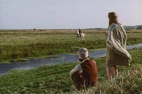 Two women stand in a field