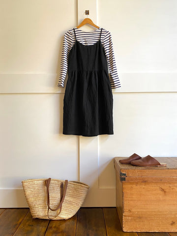 Pyne & Smith No. 34 dress in black linen layered over a long sleeve stripe top with leather mules and a tote