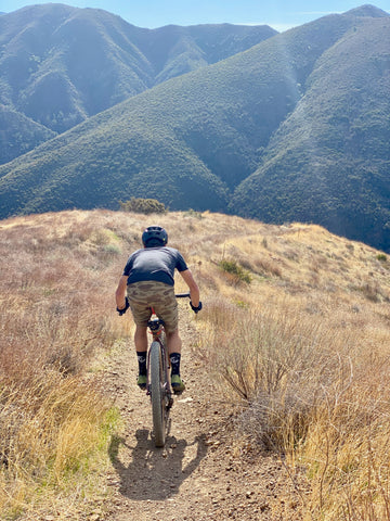 mountain biker riding a trail rear view