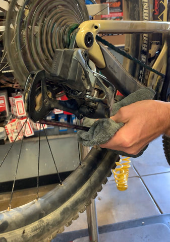 Wiping excess lube off of your bike's chain before riding. 