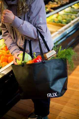 Woman loading her groceries into the RUX bag for a trip on the water.