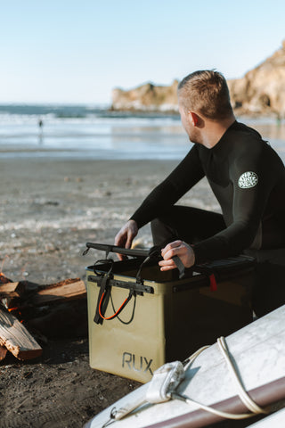 Man getting his gear out of the RUX 70L, prepping for his surf.