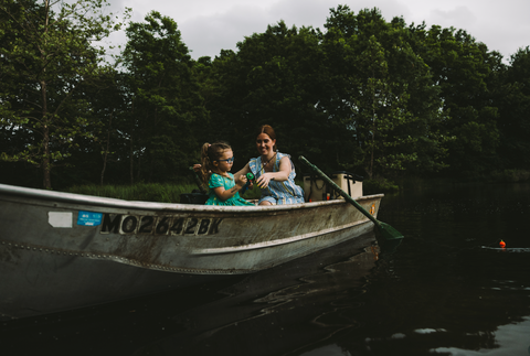 A family on their fishing boat with rainy skies and their RUX 70L beside them holding their fishing gear.