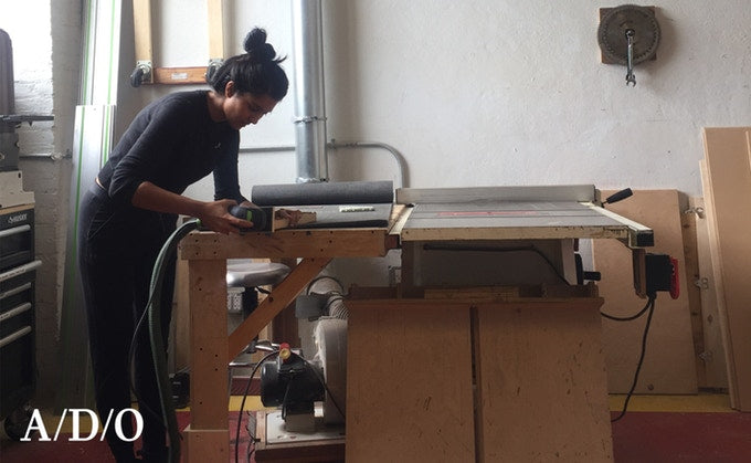 Grouphug founder Krystal Persaud sanding a Window Solar Charger's bamboo frame.