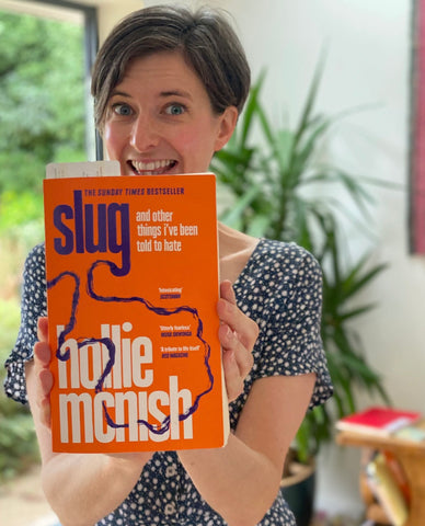 Woman with short brown hair holding Hollie McNish book - Slug with orange cover