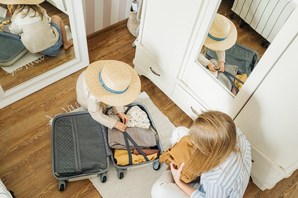 Mother and Daughter packing on the floor for vacation 