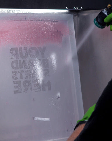 person spraying out a stencil on a screen