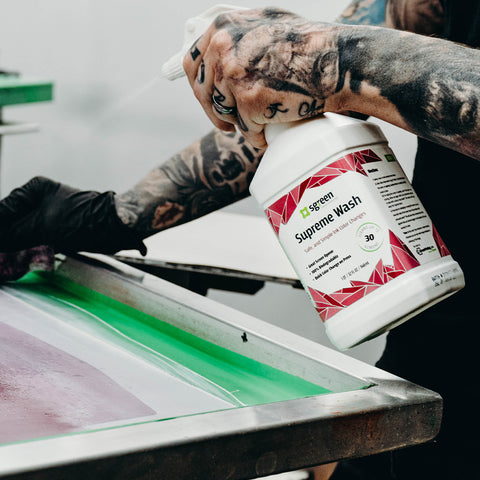 person spraying supreme wash on a screen