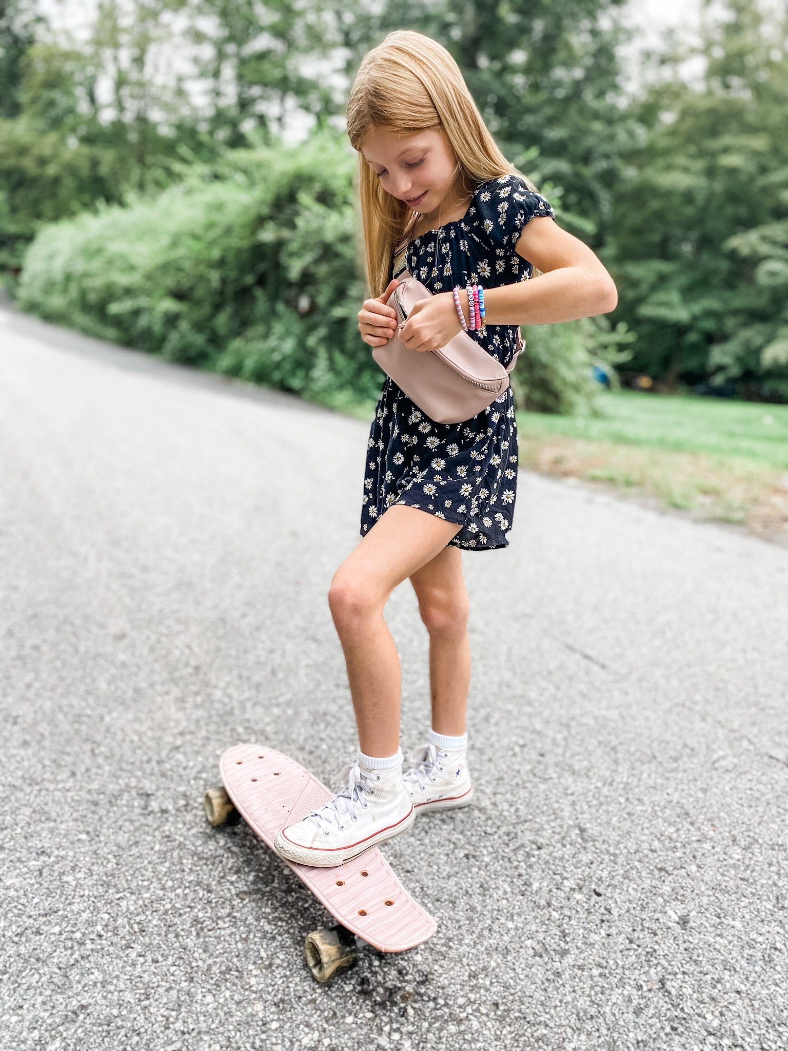 Girl wearing blush pink Kibou Mini fanny pack with skateboard