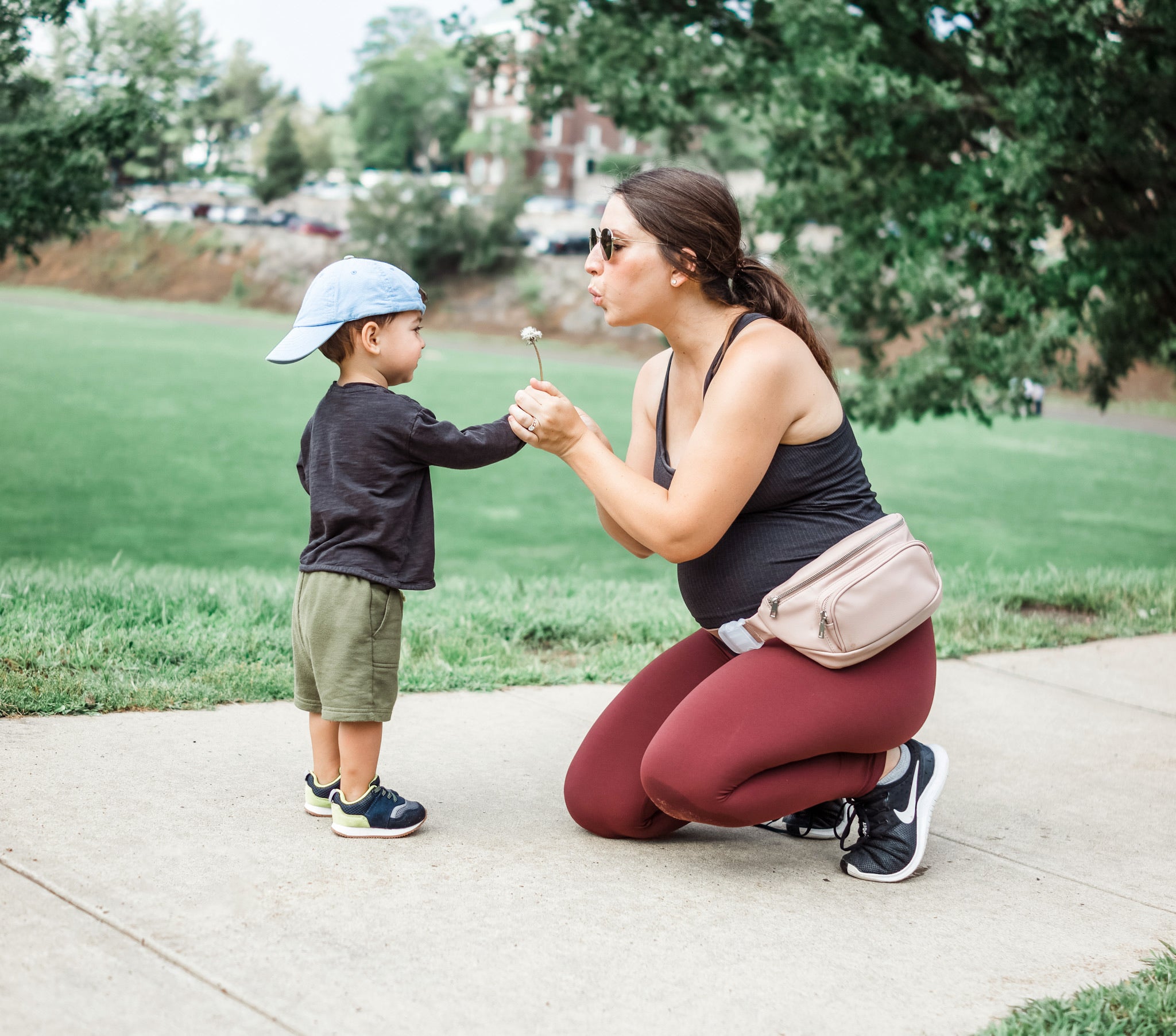 pregnant mom wearing Kibou blush fanny pack diaper bag with son in the park