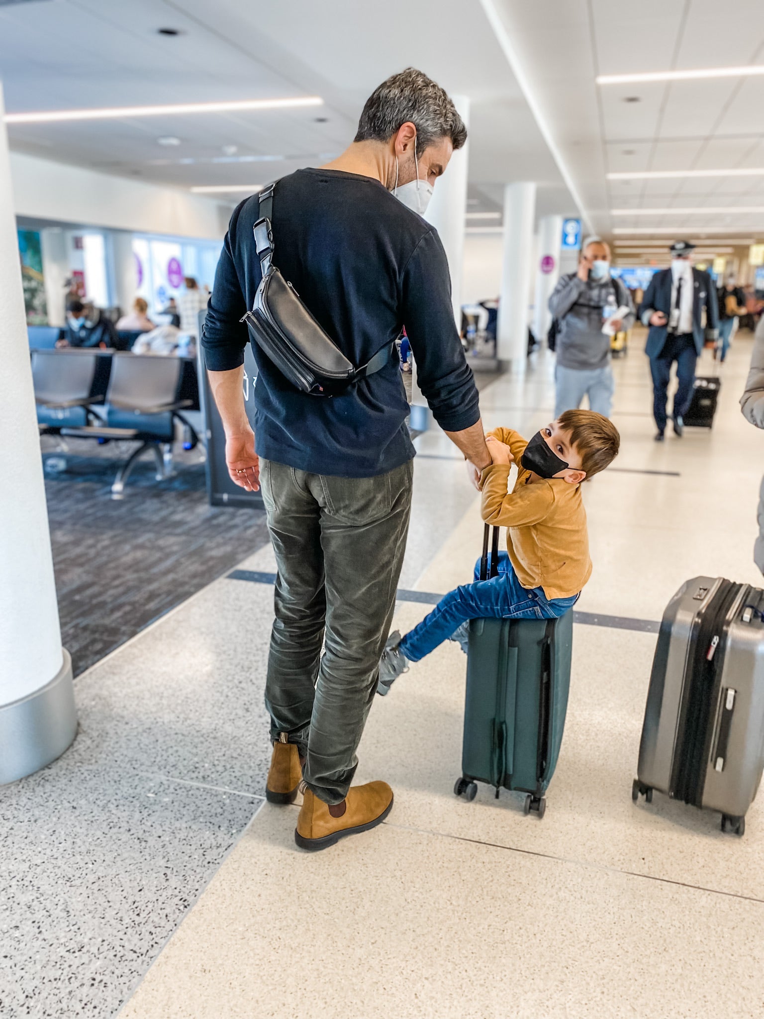 dad and toddler son at the airport getting ready to travel