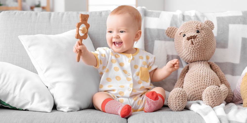 baby smiling with minimalist baby toy organic cotton brown bear