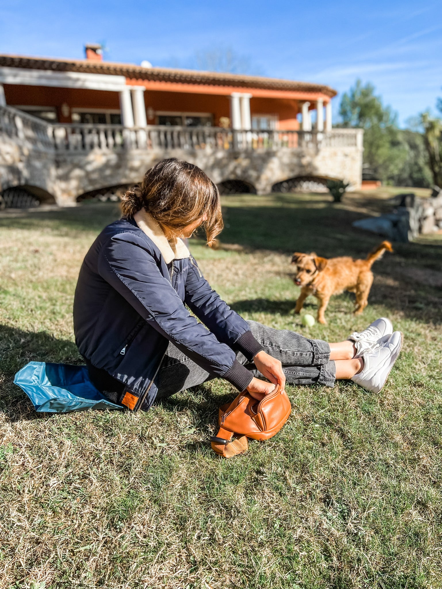 Girl Sitting with Dog and Opening Up Dog Walking Crossbody Bag