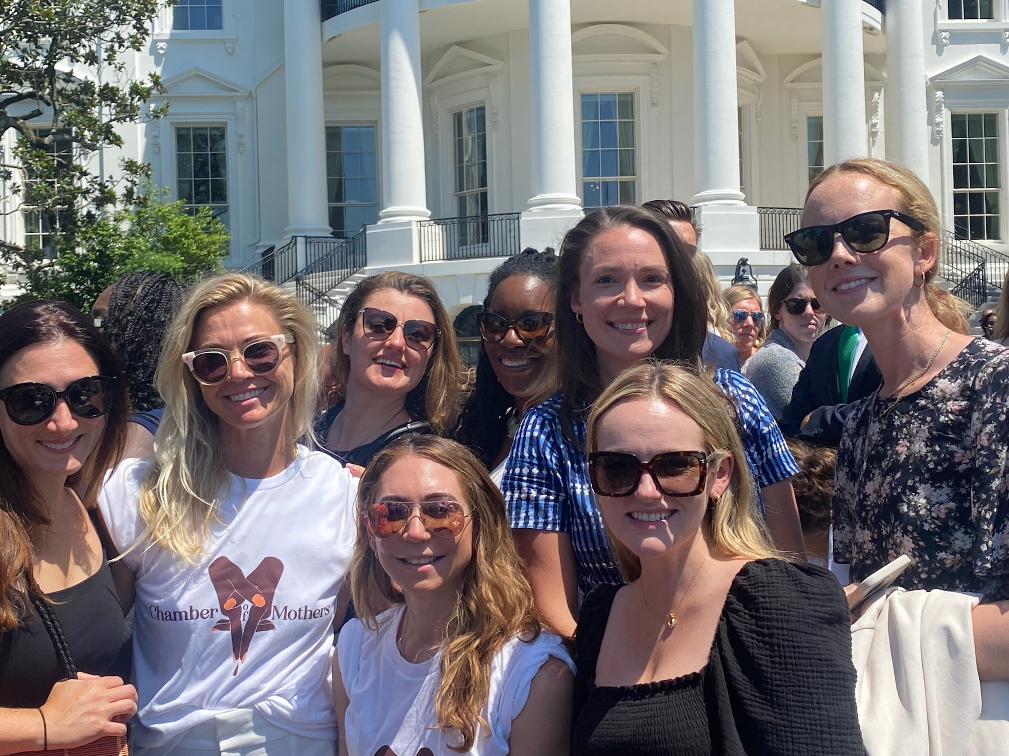 women standing in front of white house