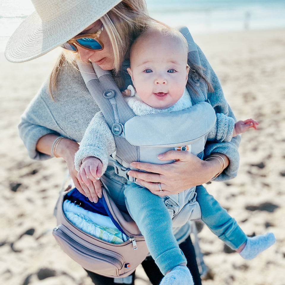 Mom with baby and Kibou diaper bag with changing pad on the beach