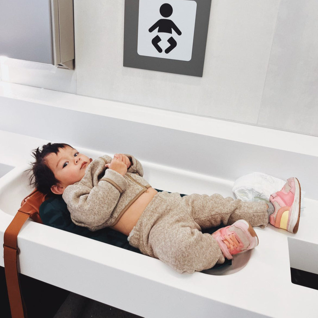 Baby on Kibou changing mat while traveling on plane