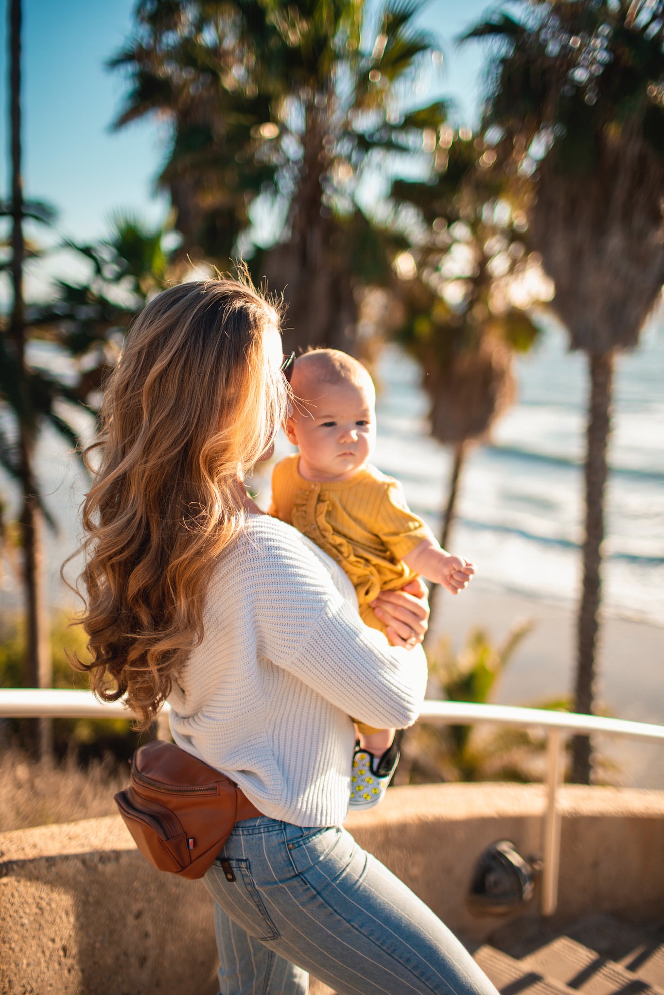 Mom wearing minimalist bag holding baby