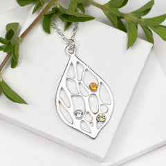 silver botanical necklace with three birthstones on white background