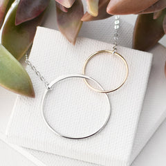 handmade linked circle necklace made of gold and silver circles on white background