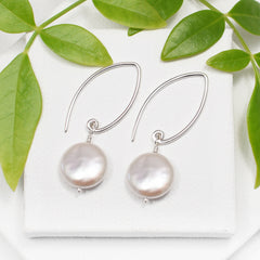 dangle coin pearl earrings on white background
