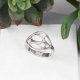 silver oval cactus ring with skeleton pattern on white blocks with succulent in background